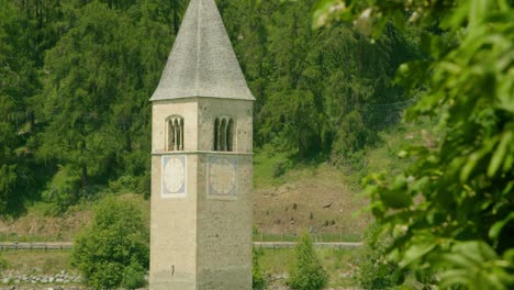 Medium-Shot,-scenic-view-of-Kirchturm-von-Altgraun-on-a-bright-sunny-day-in-Italy,-car-and-motorcycle-passing-by-the-highway-in-the-background
