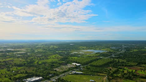 Beautiful-sky-aerial-view-moving-and-seeing-swamp-countryside-with-the-road-a-sunny-day-in-Khonkaen,-Thailand