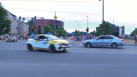 FIA-European-Rally-Trophy-2021-festive-start-and-cars-parade-at-streets-of-Liepaja-,-rally-cars-passing-spectators,-wide-angle-tracking-shot