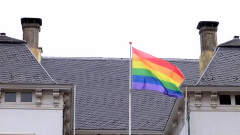 Closeup-of-rainbow-colored-LGBTQ+-flag-on-top-of-city-hall-in-Zutphen,-The-Netherlands,-waving-gently-from-the-Dutch-historic-facade-in-support-of-community