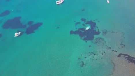 Top-down-aerial-view-of-passenger-boats-at-shallow-ocean-coast-water