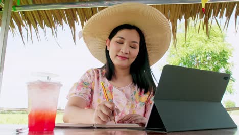 Woman-working-online-with-tablet-outdoors-with-soft-drink