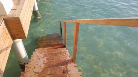 Wooden-staircase-of-ocean-villa-leading-down-into-water