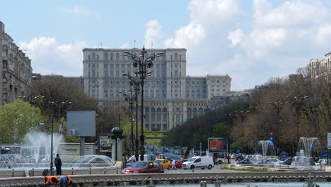 Palacio-Del-Parlamento-En-Bucarest,-Rumania-Con-Tráfico-Y-Fuentes-Durante-El-Día