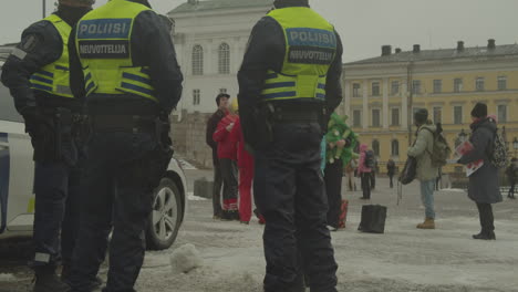 Polizisten-Stehen-Neben-Dem-Polizeiauto-In-Der-Nähe-Von-Demonstranten-Auf-Dem-Senatsplatz-Vor-Der-Treppe-Der-Kathedrale-Von-Helsinki