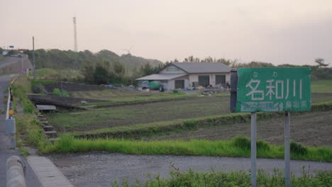 Nawa-river-sign-with-farmlands-of-Daisen,-Tottori-in-the-background