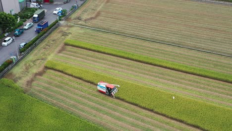 Drohnenaufnahmen-Aus-Der-Luft-Kultiviertes-Reisfeld,-Landwirt,-Der-Die-Ernte-Mit-Multifunktionalem-Reiserntemaschine-Reiserntetraktor-In-Doliu-Yunlin,-Taiwan,-Erntet