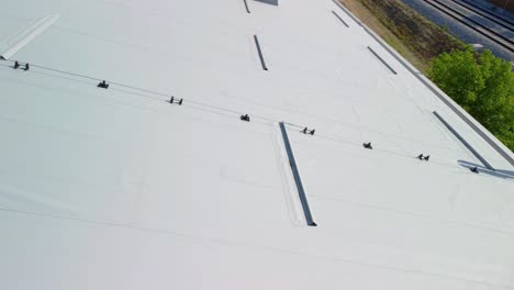 White-rooftop-insulation-panels-on-top-of-sports-hall-beside-railroad-close-up