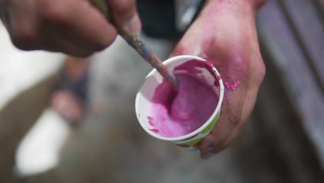 Closeup-of-artist-hand-mixing-pink-water-colour-for-graffiti