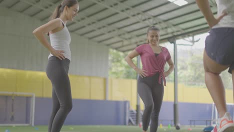chicas-utilizando-ligas-elasticas-para-ejercicio-con-los-pies-sobre-zacate-verde-y-tennis-blancas