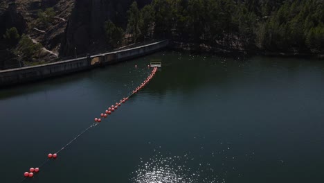 Drone-flying-over-shimmering-waters-of-Penha-Garcia-dam,-Portugal