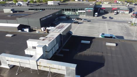 Industrial-ventilation-and-AC-unit-on-top-of-Nyborg-Storhandel-mall---Rotating-aerial-with-AC-unit-in-center-and-shops-around---Norway-Ã¥sane