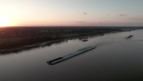 Aerial-parallax-around-tugboat-pushing-barges-up-Mississippi-River,-St
