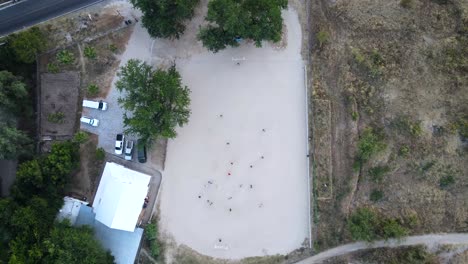 Very-high-up-drone-shot-of-kids-playing-soccer-in-Mexico
