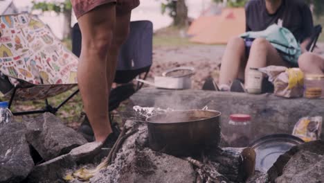 Male-Camper-Pouring-Fresh-Milk-Into-A-Hot-Pot-Of-Chai-Tea-In-Pulau-Ubin,-Singapore