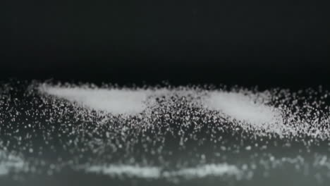 Extreme-Slow-Motion-and-Close-up-View-of-White-Salt-Grains-moving-up-and-down-Scattering-Around-with-Acoustic-Vibration