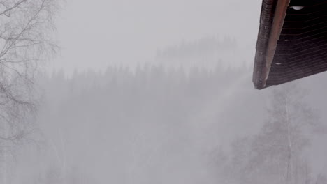 Nieve-Cayendo,-Volando-Un-Techo-Durante-Una-Tormenta-De-Nieve-Invernal,-Suecia,-Plano-Medio