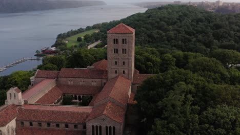 Short-close-counterclockwise-aerial-orbit-of-The-Cloisters-museum-in-Upper-Manhattan-NYC-with-the-Hudson-River-and-Hudson-Valley-in-the-distance
