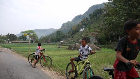 Yogyakarta,-Indonesia---May-18,-2021-:-children-in-the-mountains-in-the-village-enjoy-the-morning-cycling