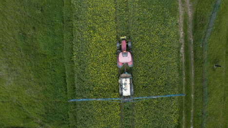 Tractor-towing-a-pesticide-sprayer-driving-in-a-green-field,overhead