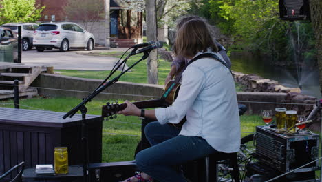 Acoustic-duo-perform-at-Dogwood-Festival-in-Siloam-Springs,-AR,-wide-shot-behind