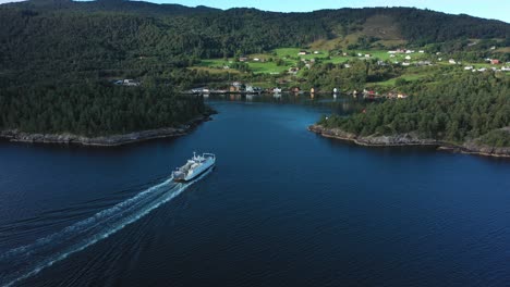 Norwegian-car-and-passenger-ferry-Ytteroiningen-approaching-port-of-utbjoa---Beautiful-aerial-view-from-the-side-and-behind-during-sunny-morning