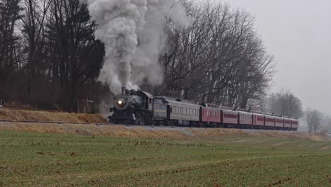 A-Steam-Engine-and-Passenger-Cars-Traveling-Up-Grade-in-a-Lite-Rain-Storm