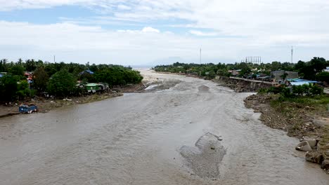 A-large-muddy-river-and-damage-on-environment-caused-by-extreme-weather-and-flash-flood-hitting-the-country-overnight,-Comoro-River-in-capital-Dili,-Timor-Leste,-Southeast-Asia