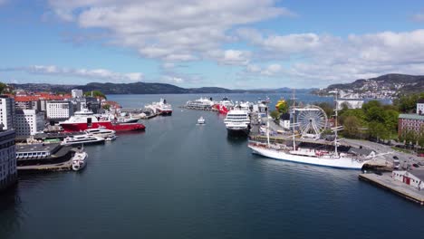 Bergen-harbour-summer-sunny-day---Ships-moored-alongside-and-express-boat-leaving-in-the-middle---Norway-aerial