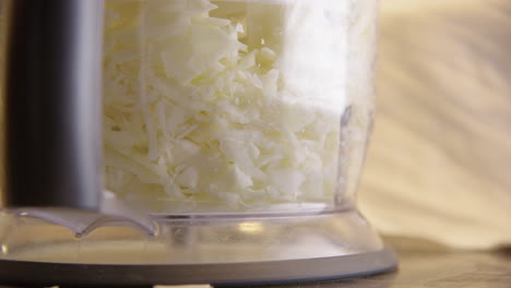 SAUERKRAUT---Food-processor-shredding-cabbage,-close-up