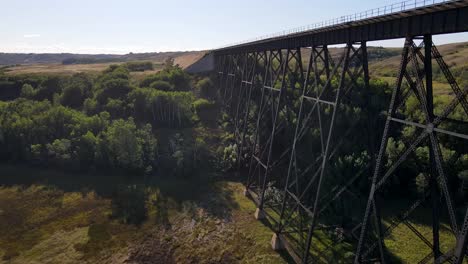 4k-drone-footage-rising-up-next-to-old-steel-bridge-and-revealing-scenery