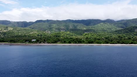 Flying-towards-a-rugged,-remote-and-secluded-mountainous-volcanic-tropical-island-covered-in-trees,-aerial-drone-of-stunning-ocean,-Atauro-Island,-Timor-Leste,-Southeast-Asia