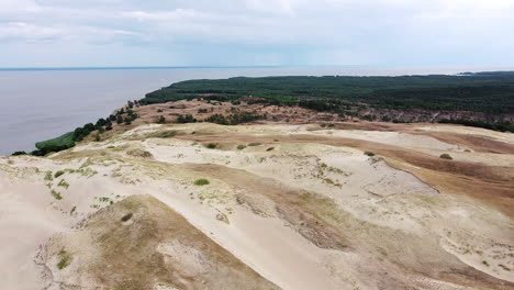 Coastline-of-Curoanian-lagoon-with-sandy-dunes-and-pine-tree-forest,-aerial-drone-view