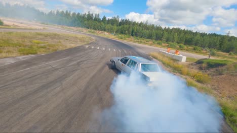 A-Grey-Volvo-740-crashing-out-of-the-drifting-track,-filmed-with-an-FPV-drone