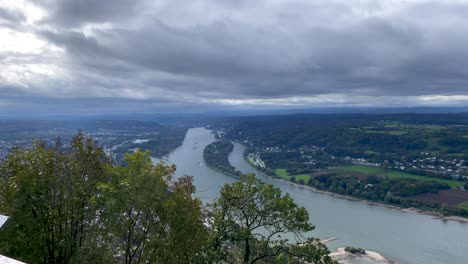 Aerial-wide-shot-of-Rhine-River-and-waving-forest-trees-during-cloudy-day-in-Germany