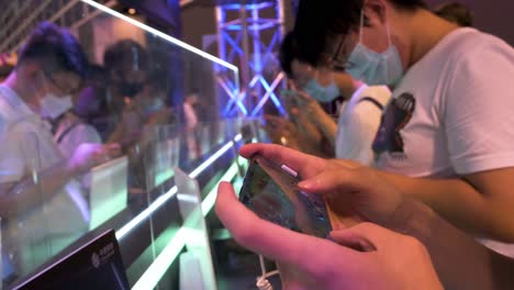 Besucher-Spielen-Videospiele-Auf-Ihren-Smartphones-Während-Der-Anicom-And-Games-Acghk-messe-In-Hongkong
