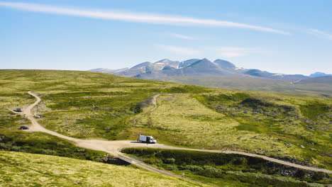 Weißes-Wohnmobil,-Das-An-Der-Straße-Mit-Natürlicher-Grüner-Berglandschaft-Im-Rondane-Nationalpark-In-Norwegen-Geparkt-Ist