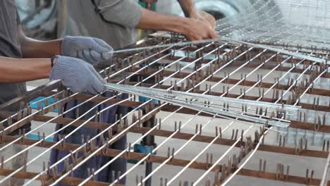 Factory-Workers-Placing-Mesh-Wire-Onto-Grid-Inside-Factory-In-Pakistan