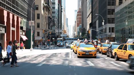 Frontal-shot-of-people-and-cars-crossing-Manhattan-square,-New-York-City