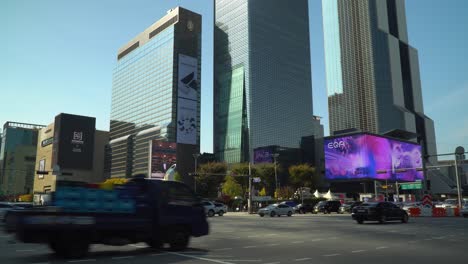 World-Trade-Center-Seoul---Autos,-Die-An-Der-Kreuzung-Am-Bahnhof-Samseong-In-Der-Nähe-Des-Coex-Trade-Tower-Und-Des-Parnas-Tower-Sowie-Des-Grand-Intercontinental-Hotels-Bei-Sonnenuntergang-Im-Herbst,-Korea,-Abbiegen