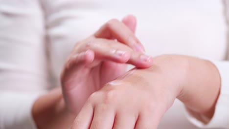 Close-up-shot-of-young-woman-hand-applying-cream-on-hand-for-skin-care-massage-daily