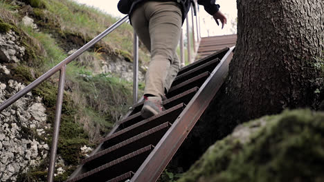 Hiker's-boots-and-pants,-person-climbing-up-metal-stairs-in-outdoor-path