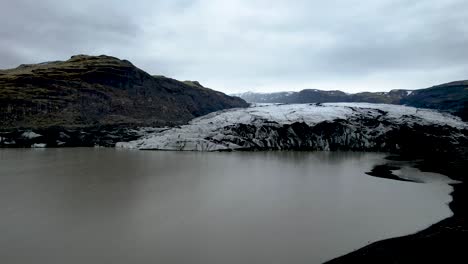 Drone-Volando-Sobre-Un-Lago-Glacial-Y-Sobre-El-Borde-Del-Glaciar-En-Islandia