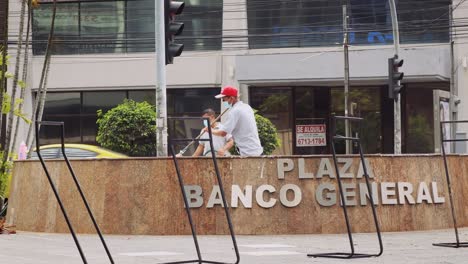 Two-cleaners-in-white-t-shirt-washing-the-Calle-50,-Plaza-Banco-General-in-the-road-of-PanamÃ¡-City-,-Panama