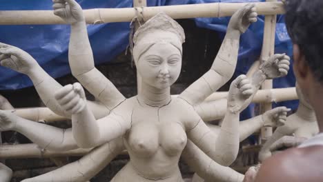 Arme-Indische-Handwerker-Geben-Einem-Idol-Der-Hinduistischen-Göttin-Durga-Für-Das-Durga-Puja-Fest-Den-Letzten-Schliff,-Zeitlupe