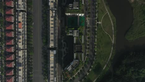 Top-down-aerial-view-of-ultra-modern-lakeside-housing-and-apartment-development-on-a-sunny-day-with-park,-green-space,-bridges-and-new-architecture