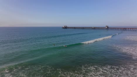 surfers-riding-waves-at-Oceanside-beach,-CA