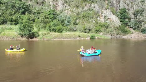 Low-aerial-pans-with-river-rafting-group-as-they-float-the-Snowy-River