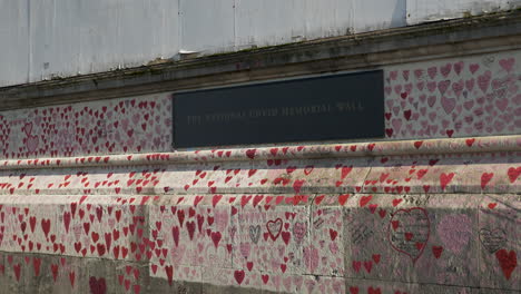 The-plaque-which-commemorates-the-National-Covid-Memorial-Wall,-the-wall-covered-in-thousands-of-hand-drawn-pink-hearts-serving-as-a-memory-for-those-who-have-died-due-to-the-pandemic,-London,-England
