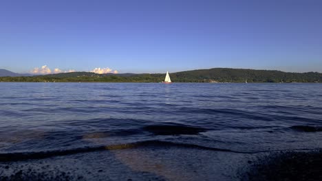 Horizontale-Low-Angle-Ansicht-Eines-Roten-Segelboots,-Das-Auf-Dem-Seewasser-Segelt